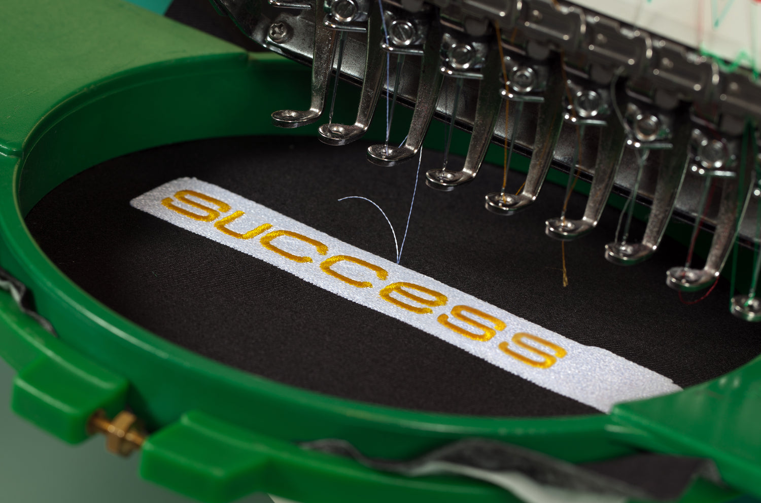 Exquisite Craftsmanship: Close-Up of Embroidery Process with Logo in Embroidery Frame, Creating Elegant and Detailed Designs